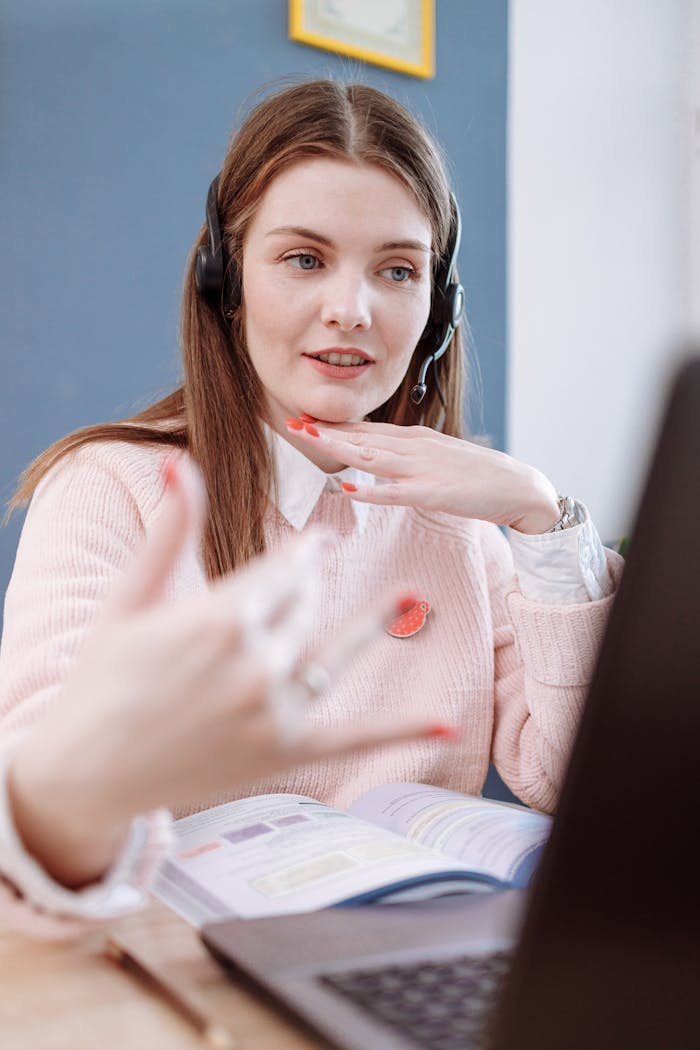 The Art of Drawing Readers In: Your attractive post title goes here Woman wearing headset teaches online using a laptop from home, engaging in a virtual lesson.