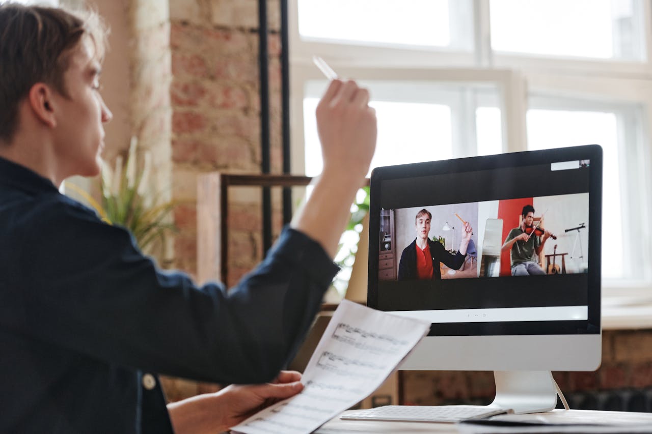 Mastering the First Impression: Your intriguing post title goes here A man participates in a virtual music lesson, interacting with a violin teacher via video call.